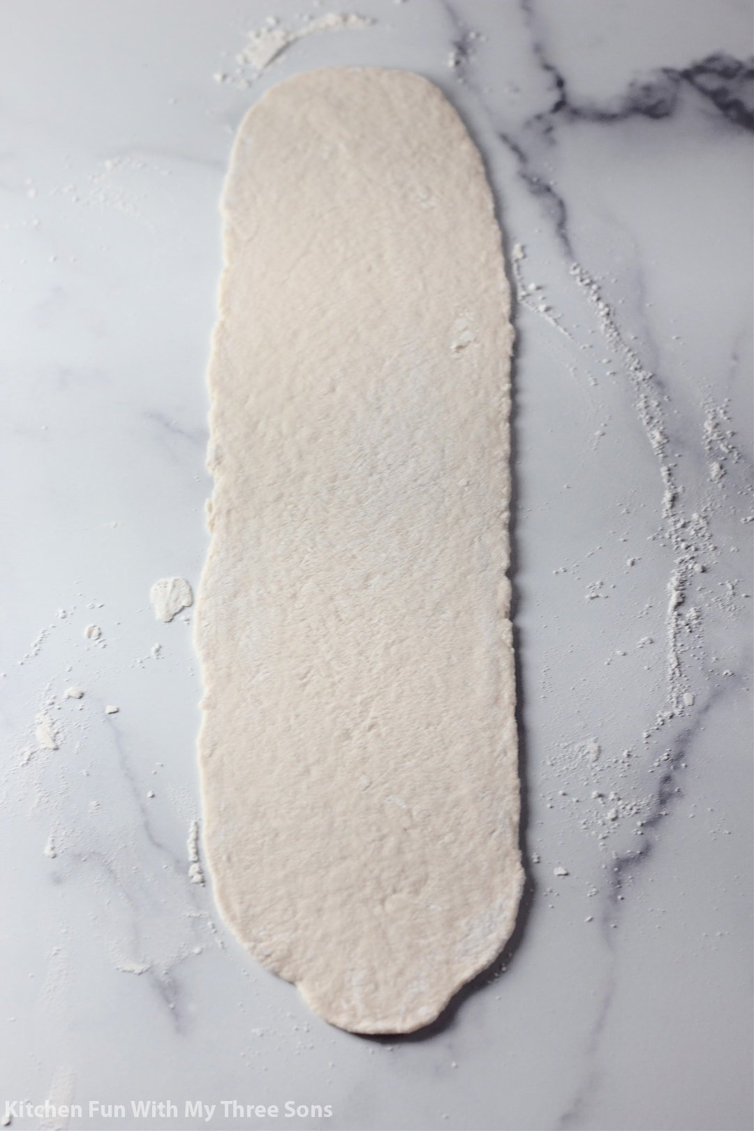 cinnamon roll dough rolled out on a counter