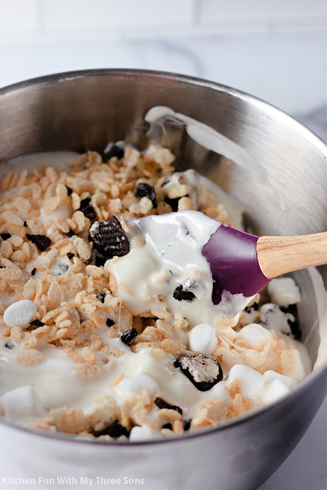 stirring together the rice krispies with the melted marshmallows