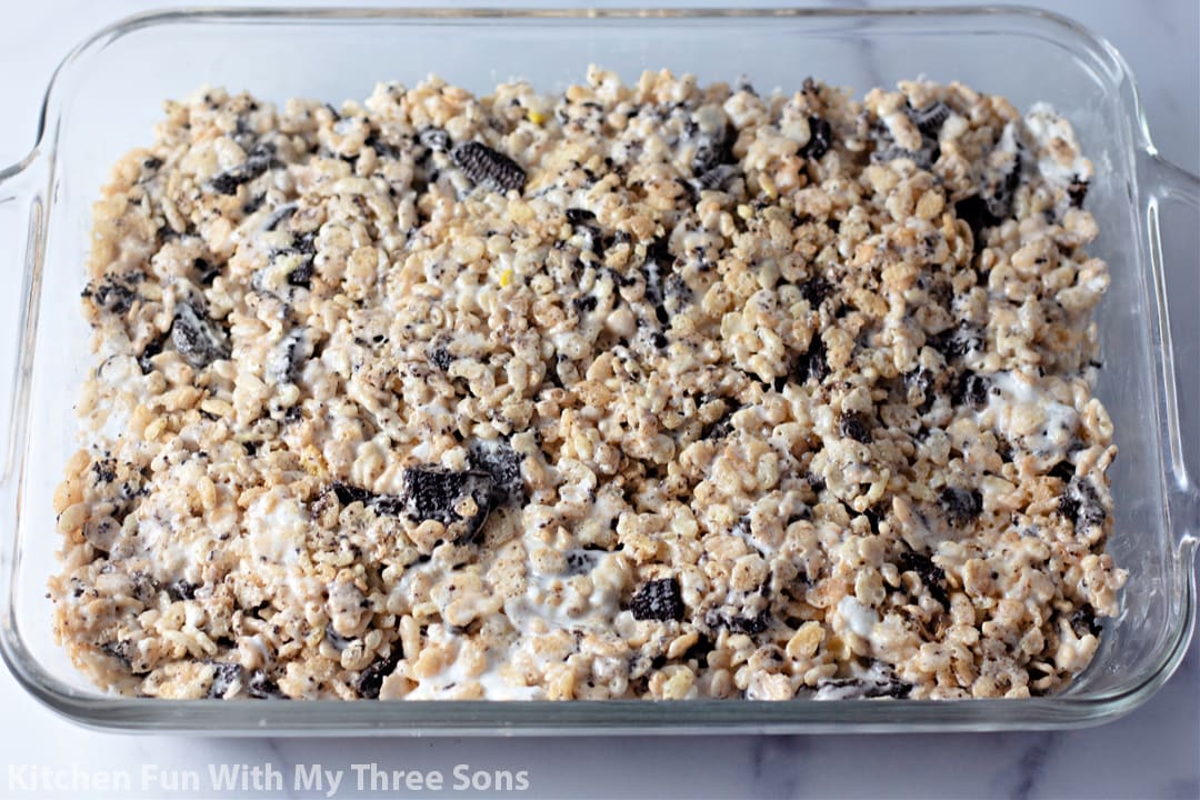 pressing the rice krispie treats into a glass dish