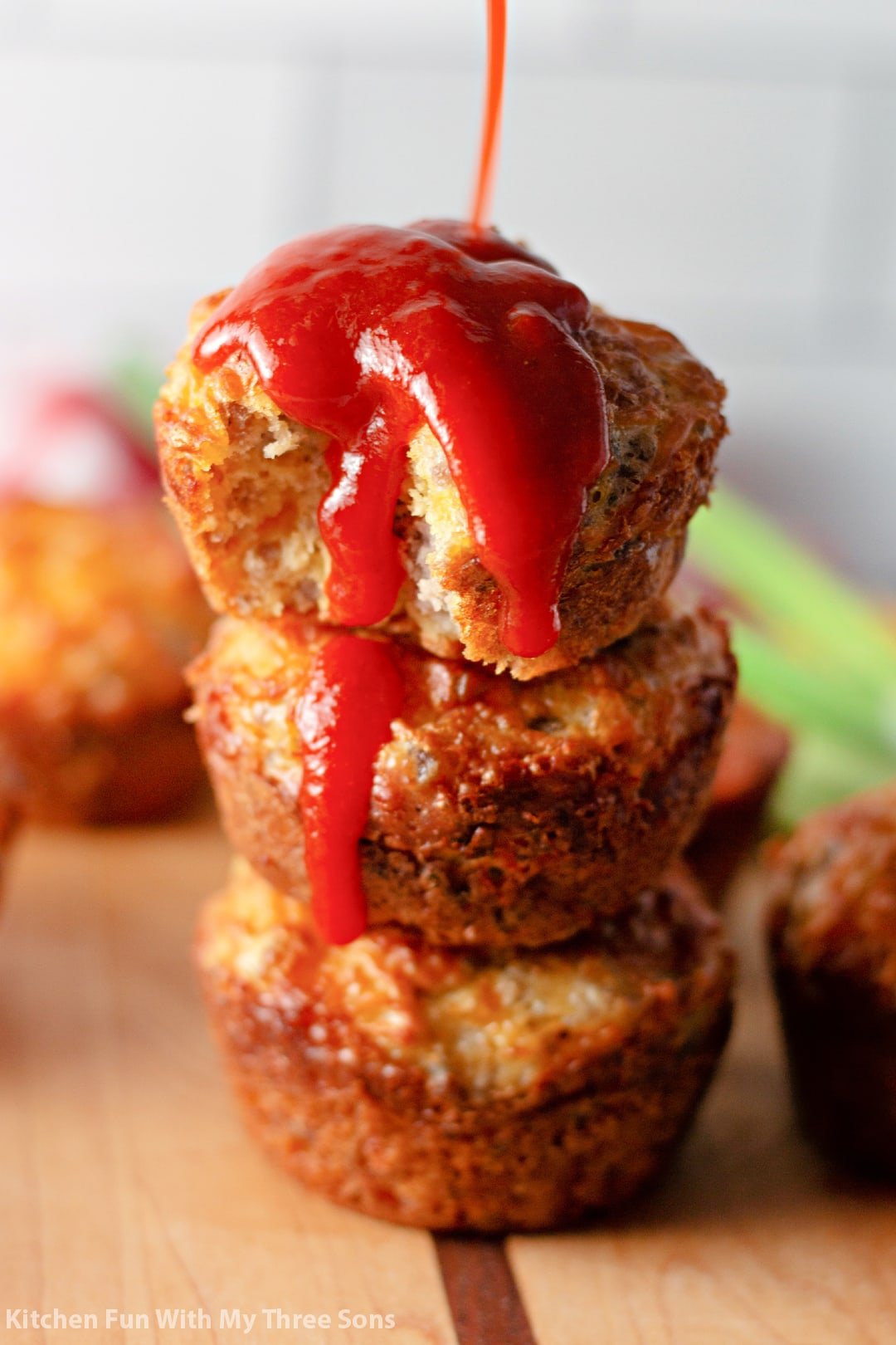 pouring hot sauce over Sausage Breakfast Muffins