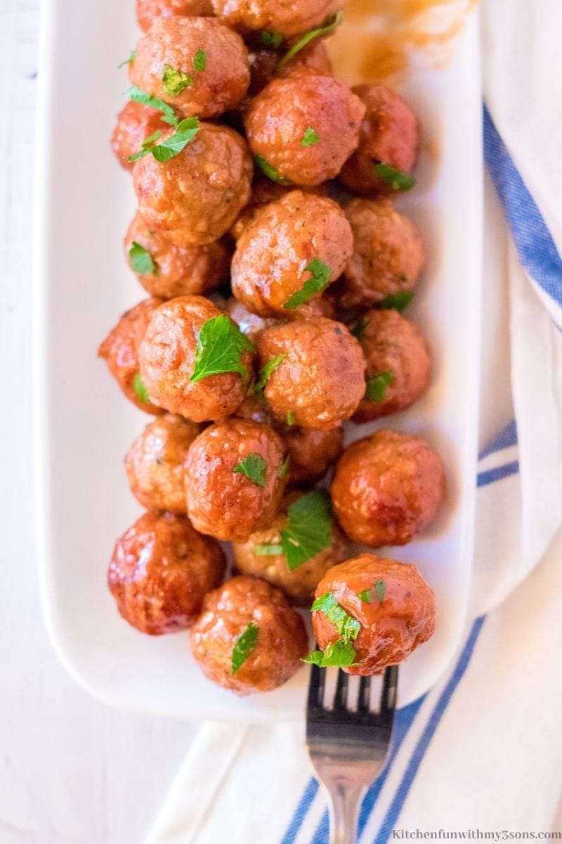 The meatballs on a platter with a white cloth next to it.
