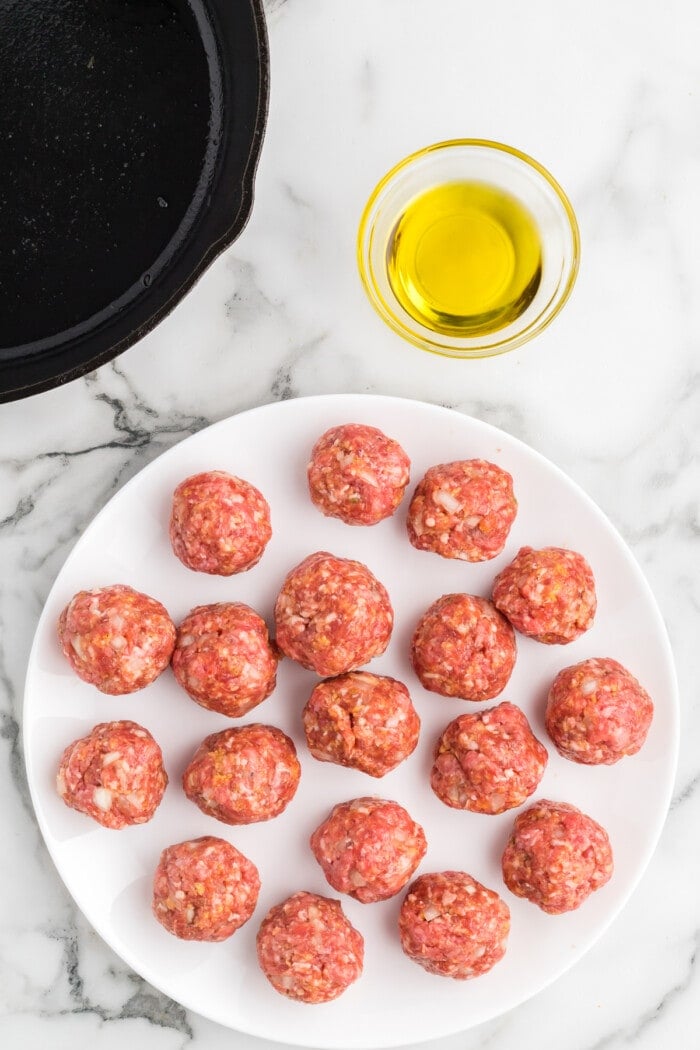 Raw meatballs on a white plate