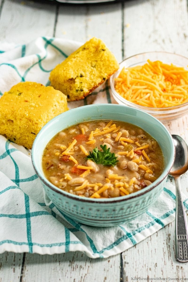 The Best Bean and Bacon Soup Recipe with a side of bread and more cheese.