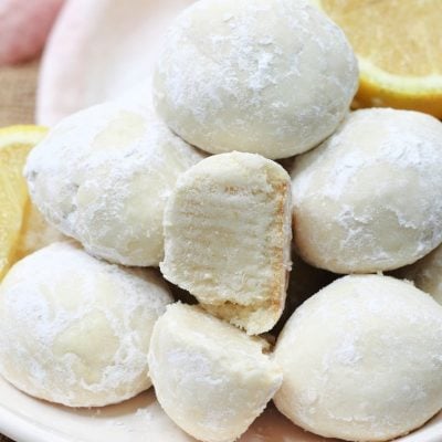 Lemon Snowball Cookies on a plate with lemons