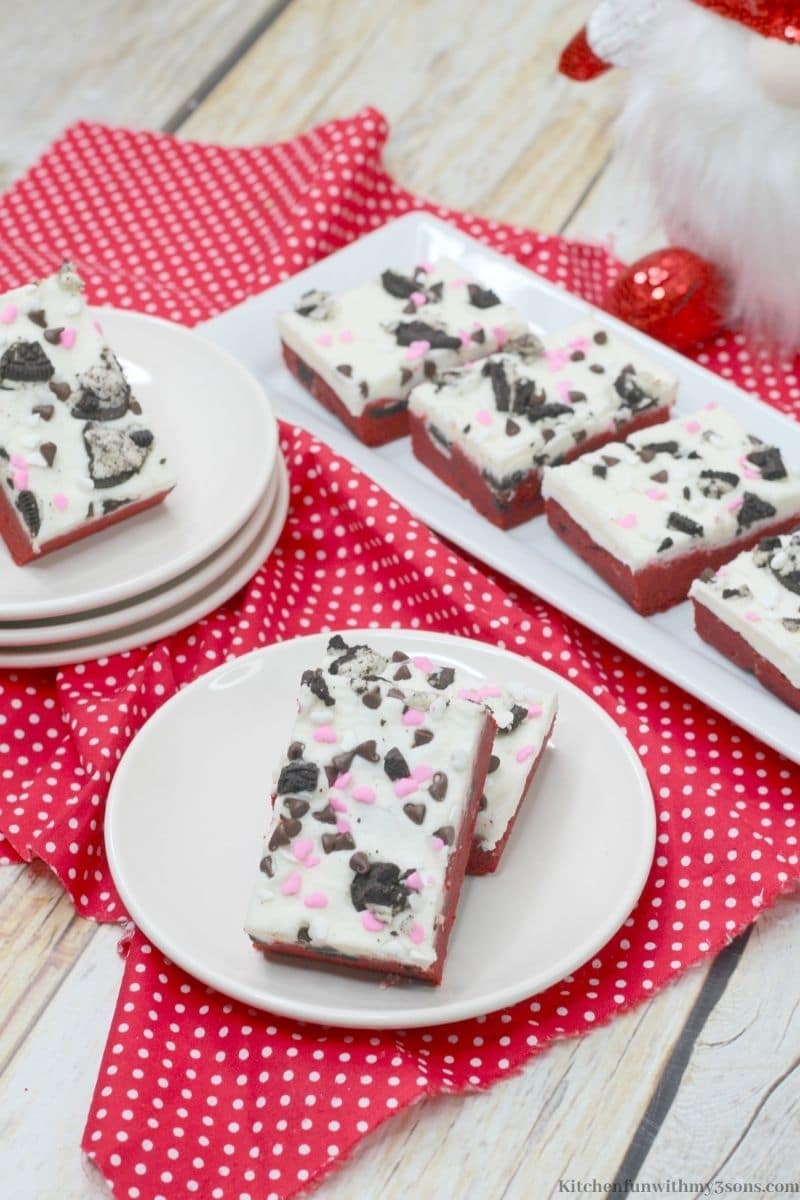 The cookie bars on separate serving dishes on a white and red polka dot cloth.