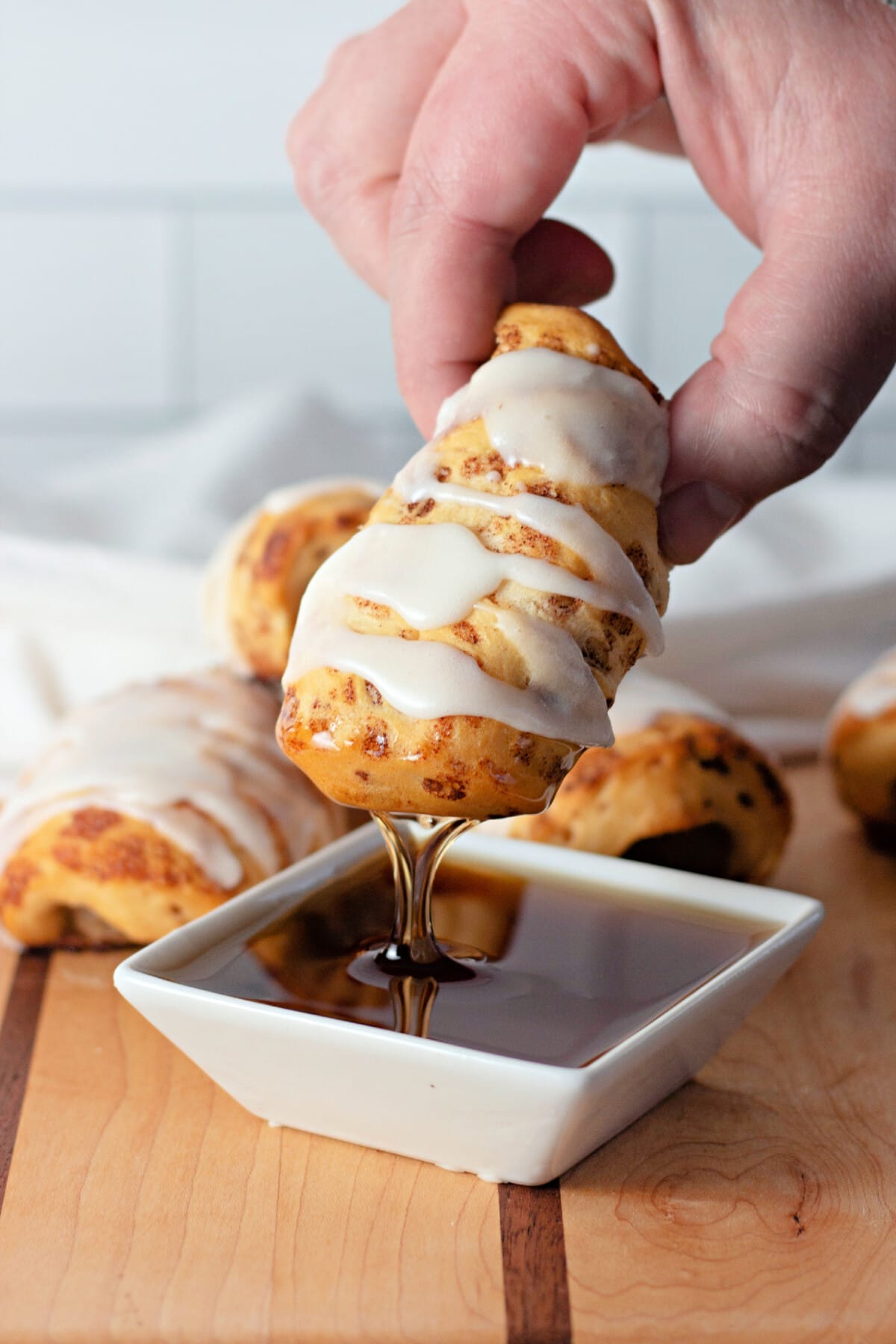 Dipping Breakfast Pigs in a Blanket into syrup