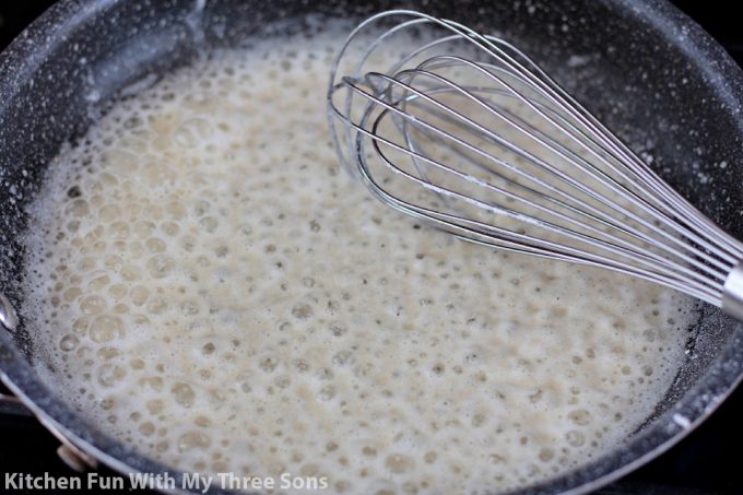 whisking the roux in a skillet.