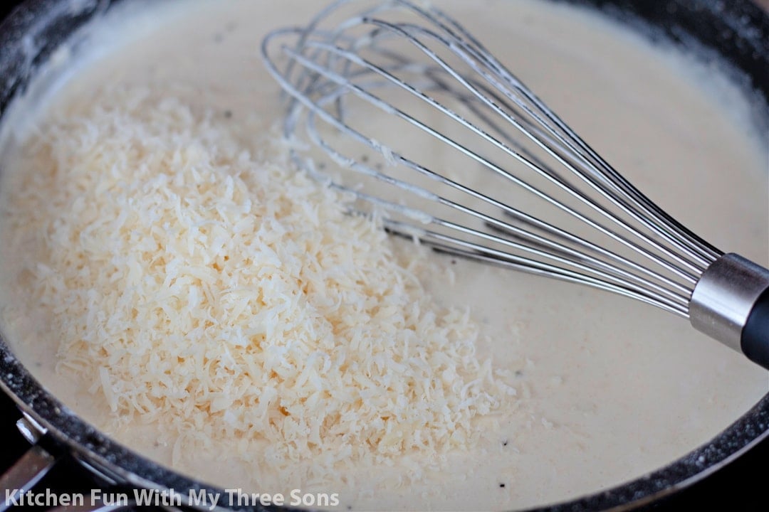 whisking cheese into the cream sauce.