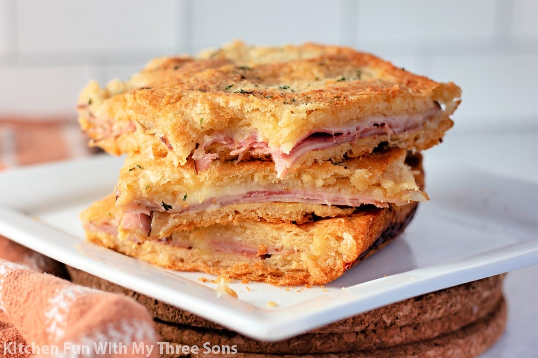 Baked Ham and Cheese Sandwiches on a white plate.
