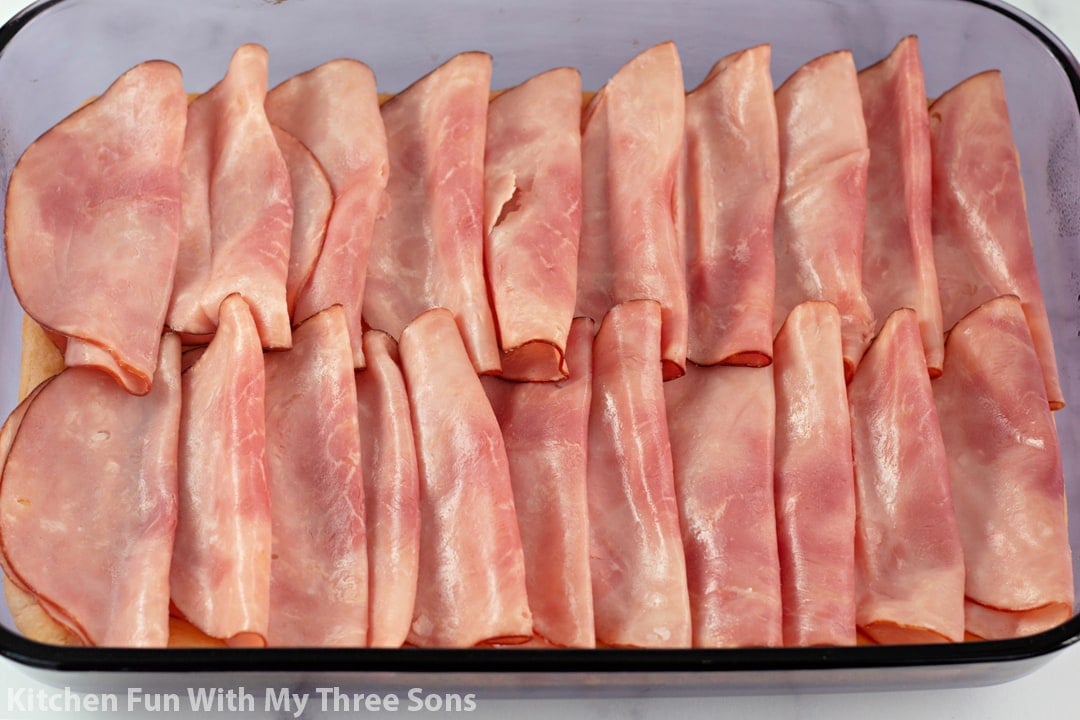 adding meat to the sandwiches.