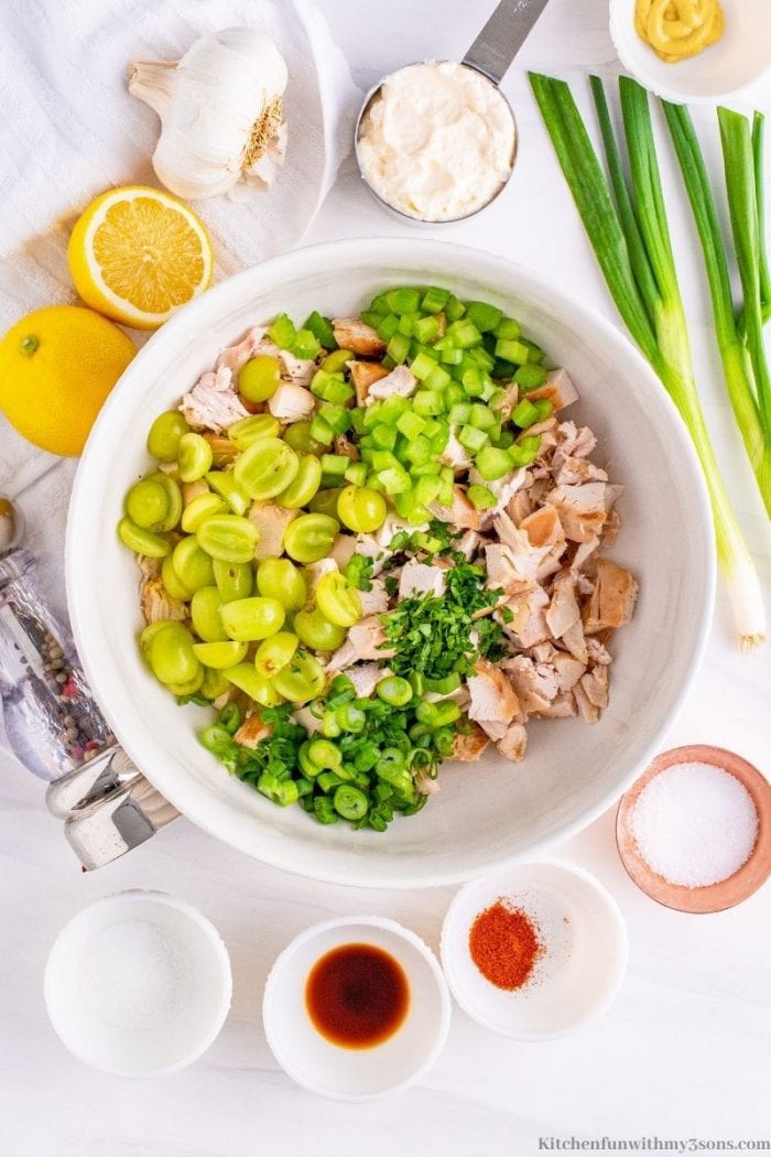 Chicken, celery, green grapes, and herbs in a bowl