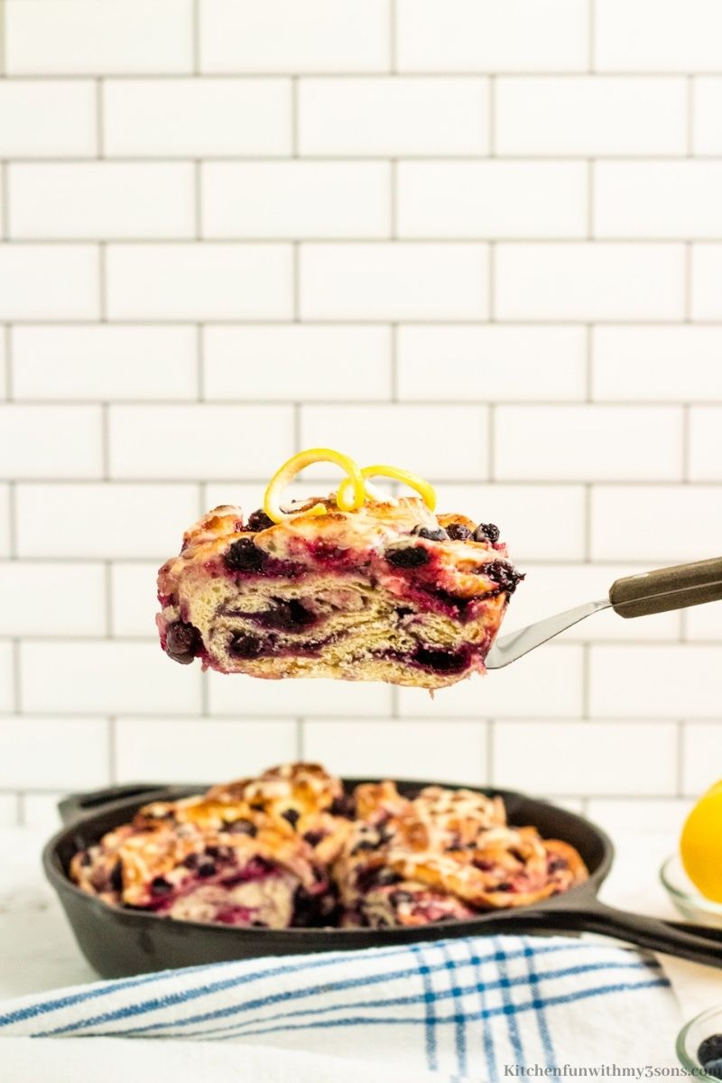 A spatula lifting up a piece of the Lemon Blueberry Bread.