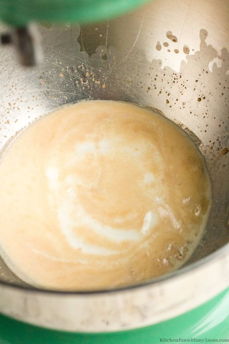 The warm milk in a bowl dissolving the sugar and yeast.