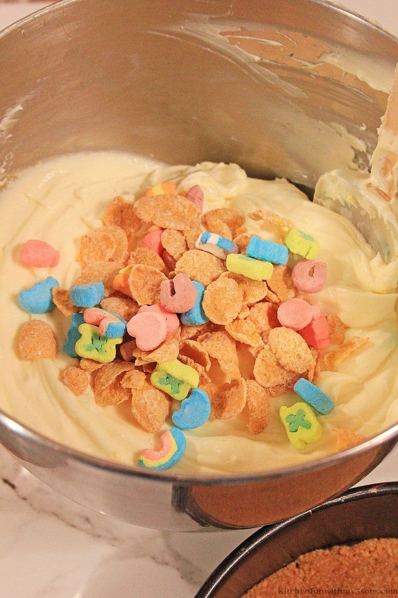 Folding in the marshmallows and frosted flakes into the batter.