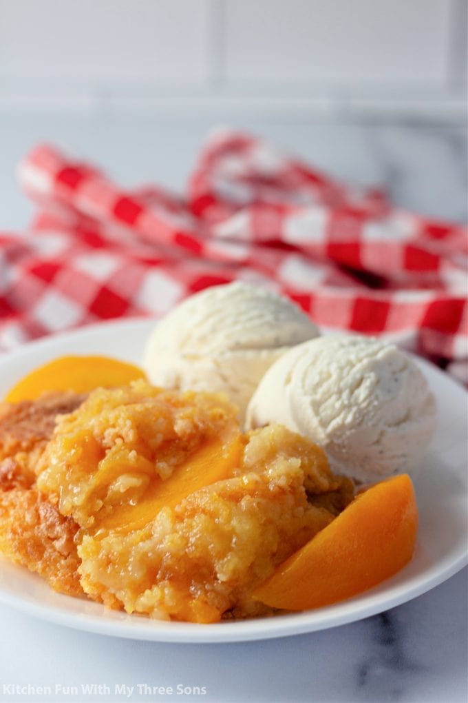 Easy Peach Dump Cake with a red and white checkered napkin.
