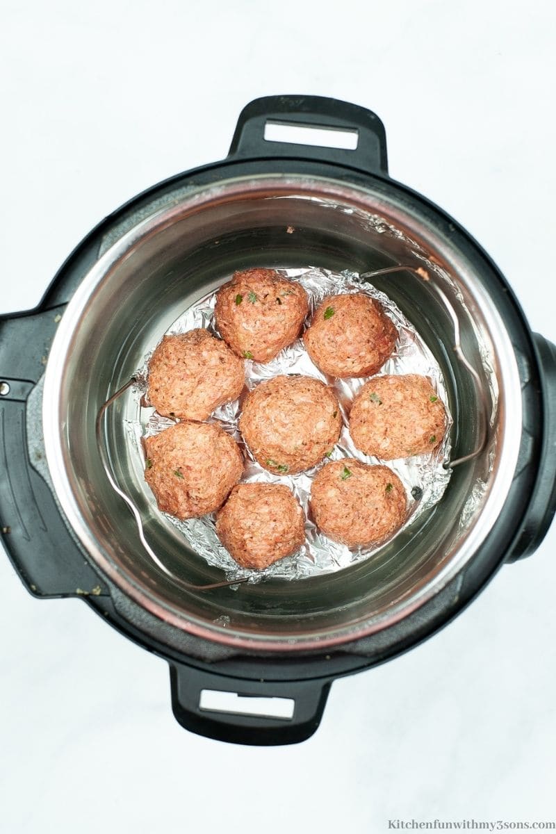 The meatballs on a trivet inside of the Instant Pot.