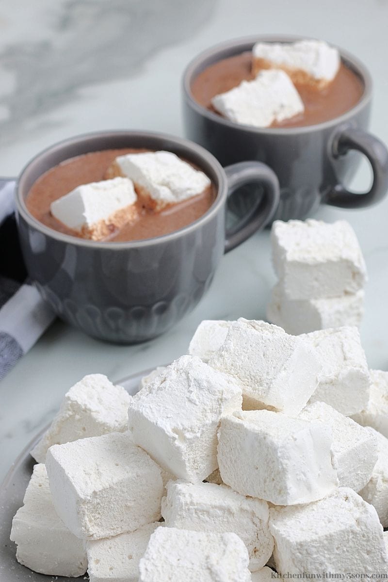 The marshmallows with cups of hot cocoa with marshmallows in it.