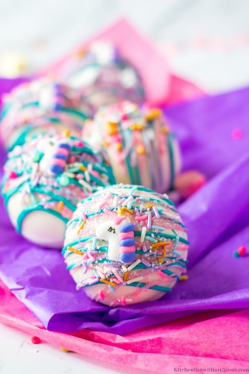 A close up of the Unicorn Hot Chocolate Bombs on the colored tissue paper.
