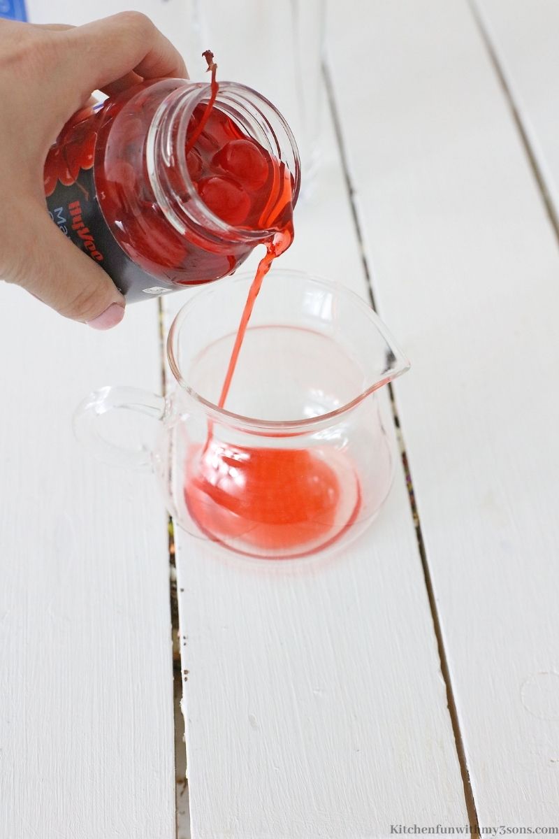 Pouring the cherry juice into a small pitcher.