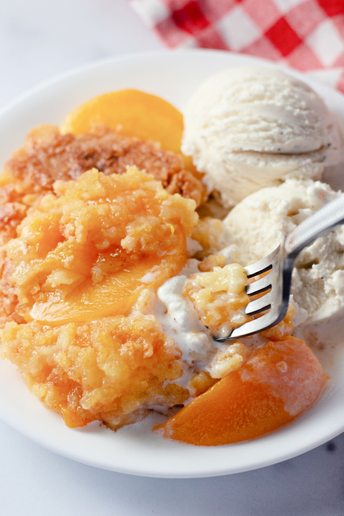 Peach Dump Cake on a plate with Ice Cream
