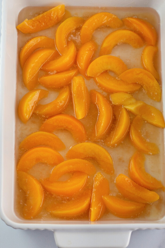 canned peaches in a glass baking dish