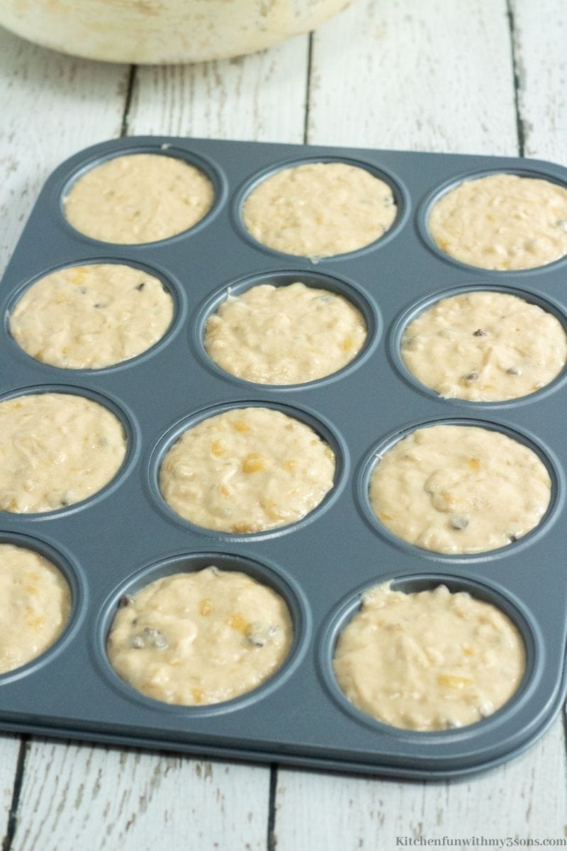 Pouring the batter into the prepared muffin pans.