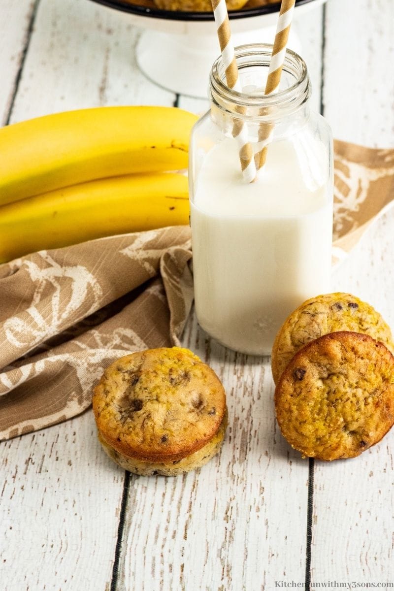 Chocolate Chip Banana Muffin Tops with bananas and a milk glass with straws inside.