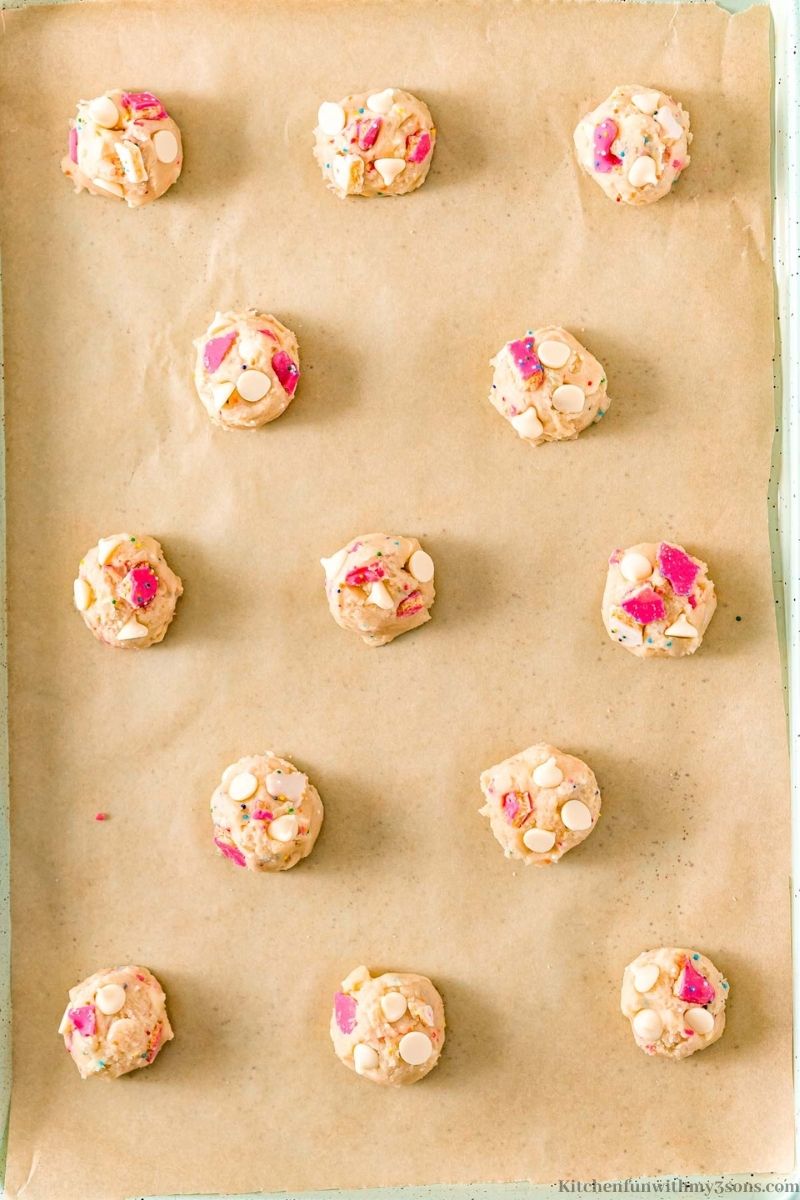 Medium cookie dough balls arranged onto a prepared sheet.
