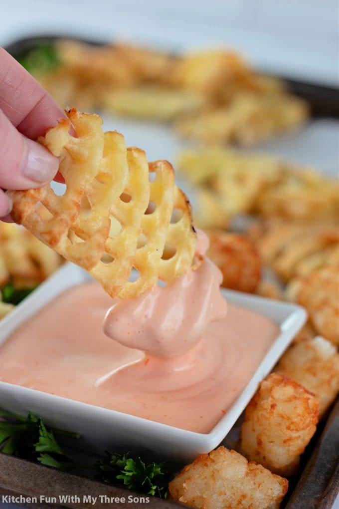 dipping a waffle fry into campfire sauce.