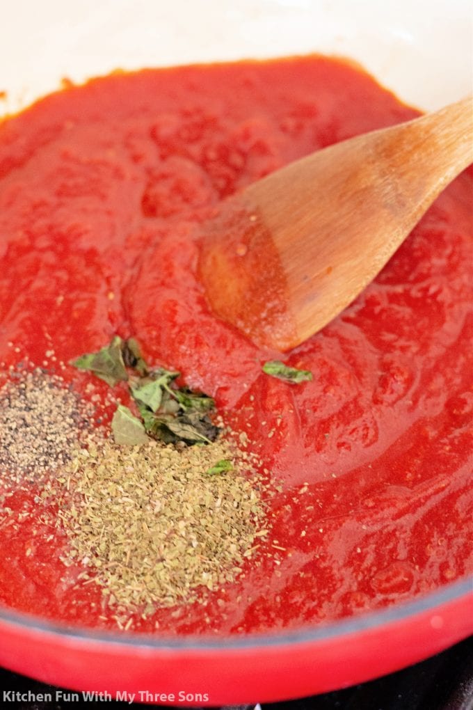 stirring spices into tomato sauce.