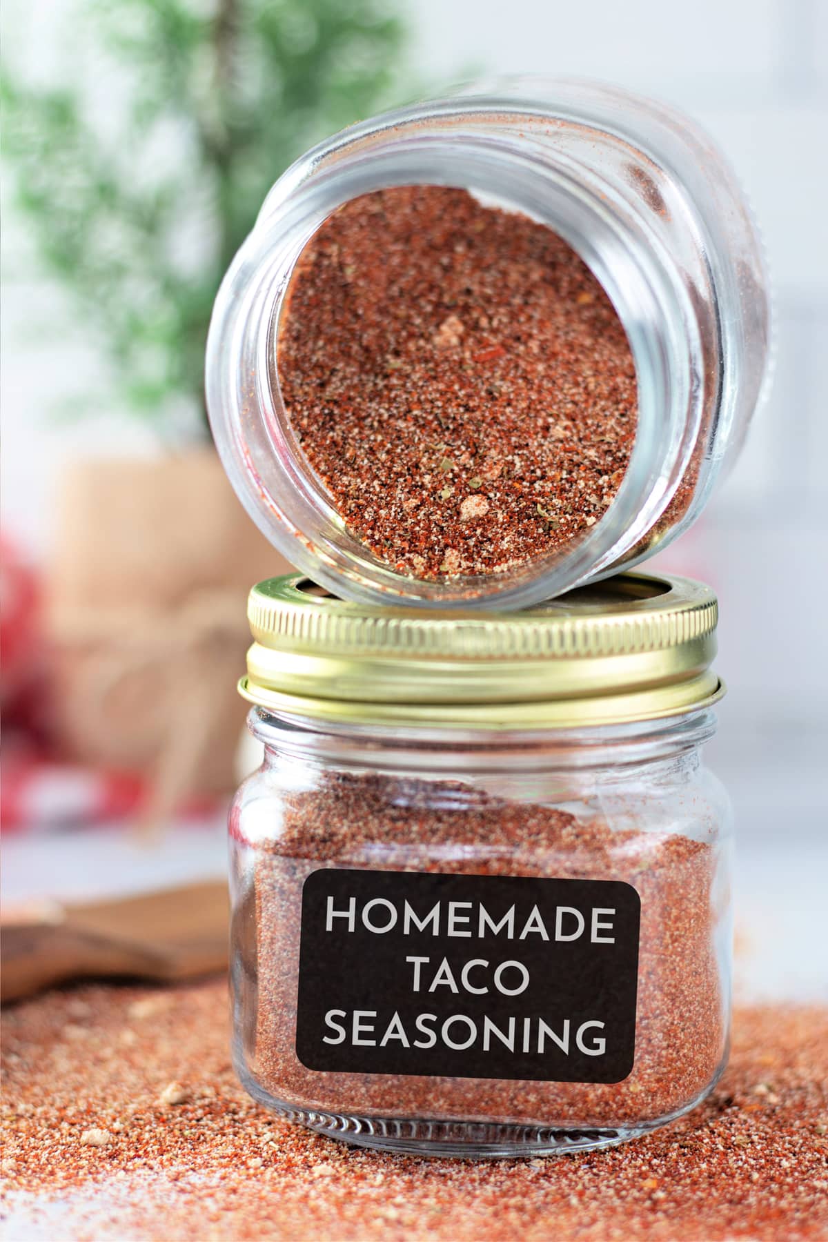 A jar of taco seasoning on its side over a second jar