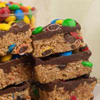 No-Bake Monster Cookie Bars are a thick layer of peanut butter cookie filled with M&M's and topped with a delicious layer of chocolate.