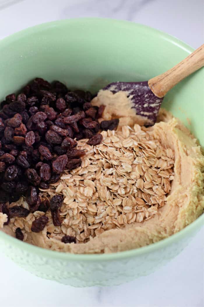 Stirring chocolate chips and oats into cookie dough