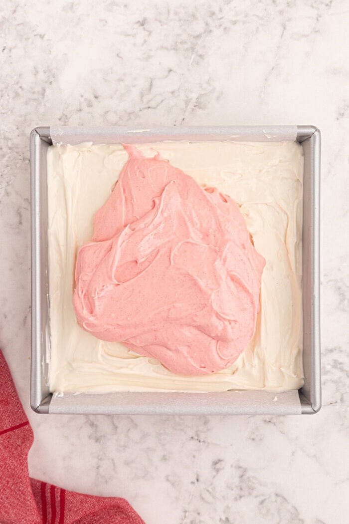 Strawberry cream cheese mixture added on top of a cream cheese mixture