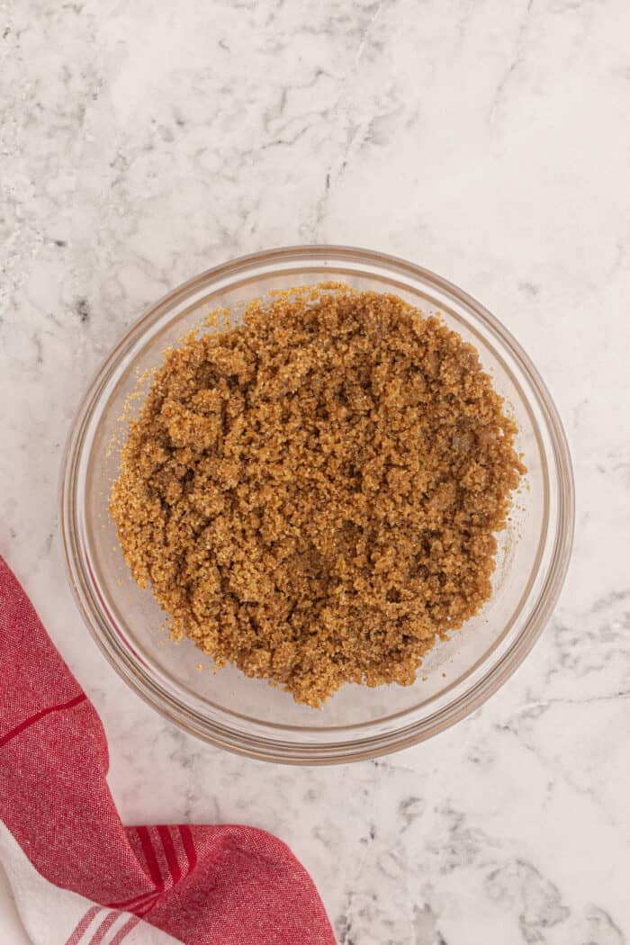 Graham racker crumbs and melted butter in a bowl