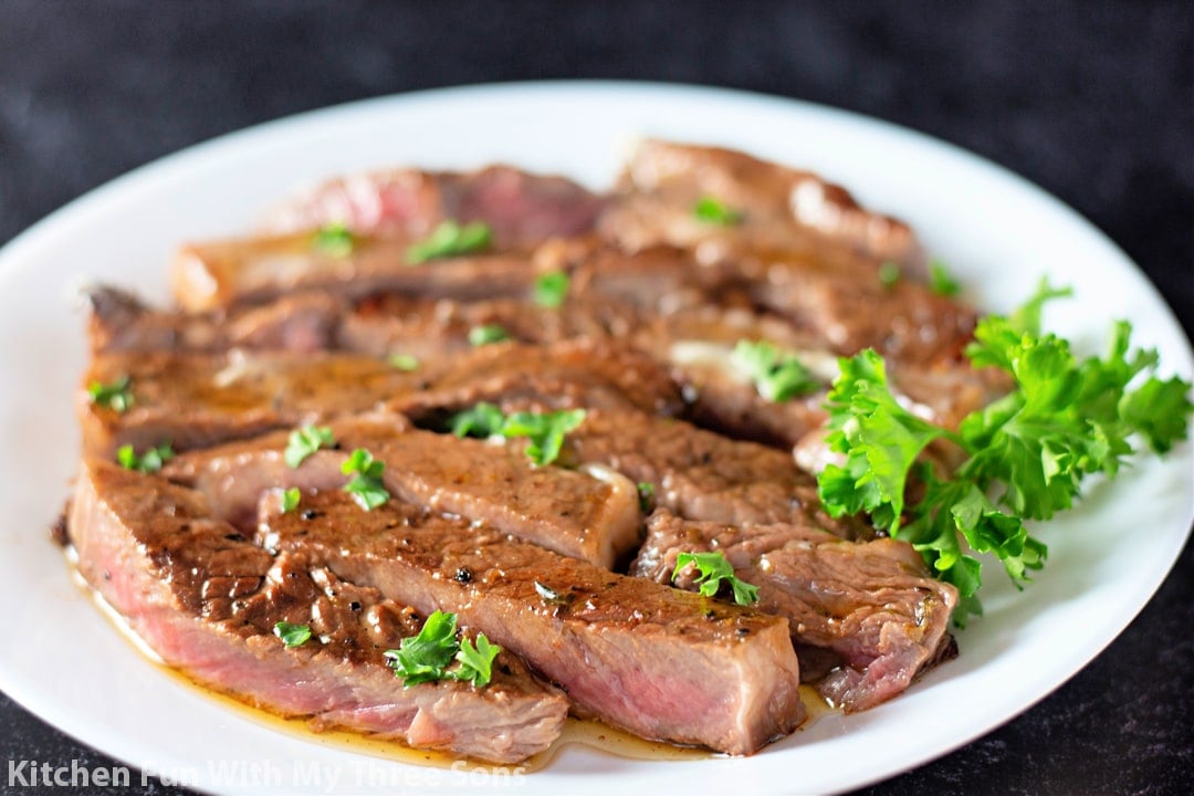 steak cut into strips on a white plate.