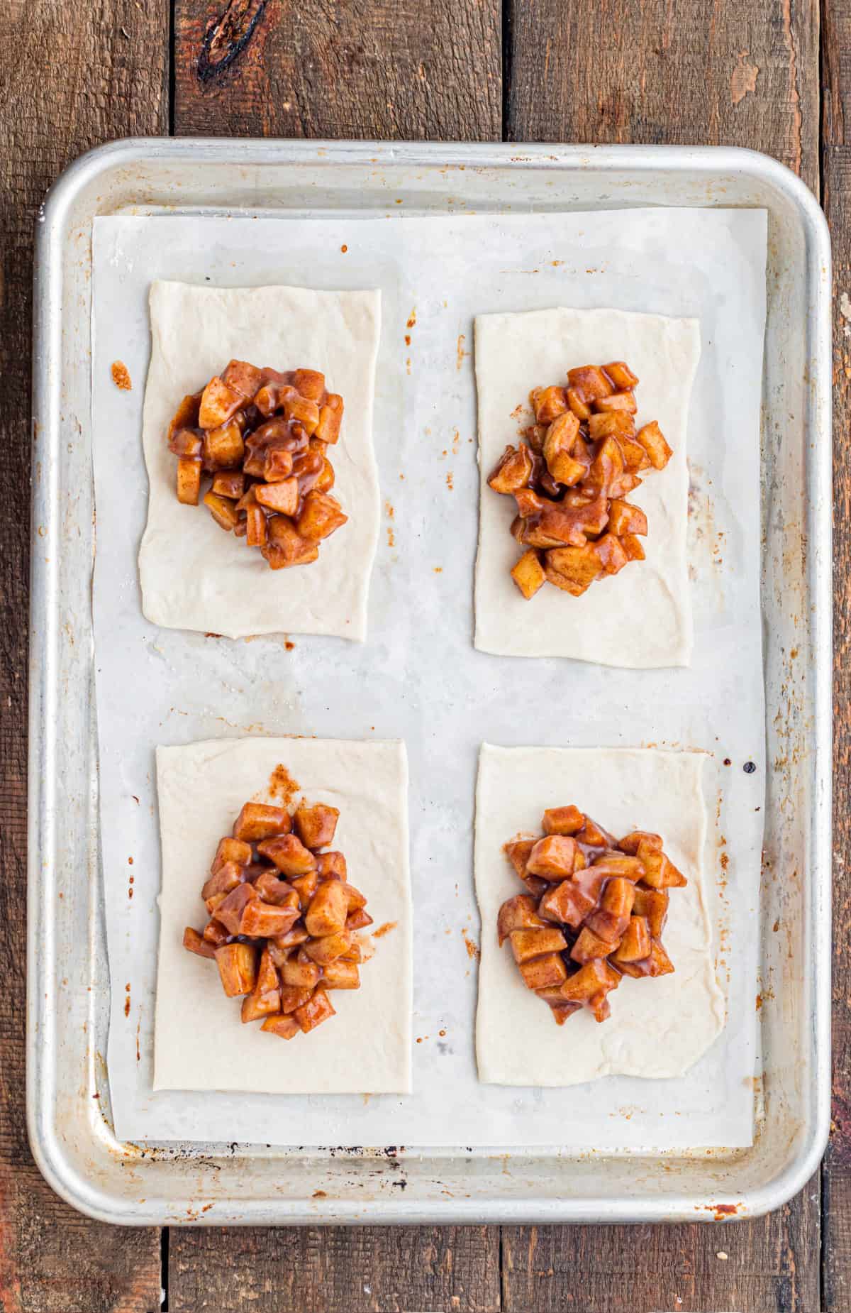 These Apple Hand Pies are filled with gooey apple pie filling wrapped in flaky puff pastry and baked until deeply golden and crisp. adding the apple pie filling to the puff pastry squares.