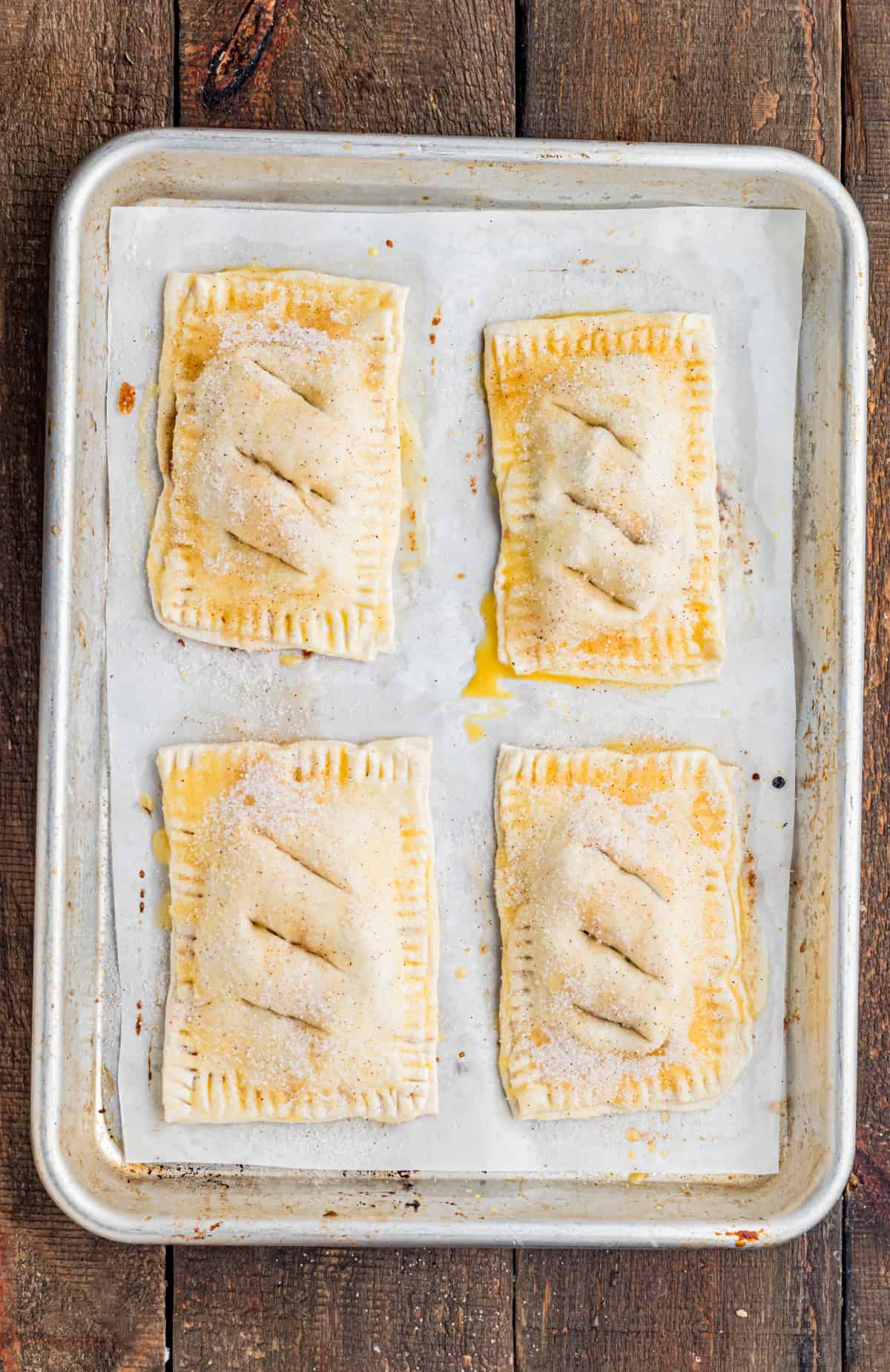 These Apple Hand Pies are filled with gooey apple pie filling wrapped in flaky puff pastry and baked until deeply golden and crisp. adding the egg wash to the puff pastry.