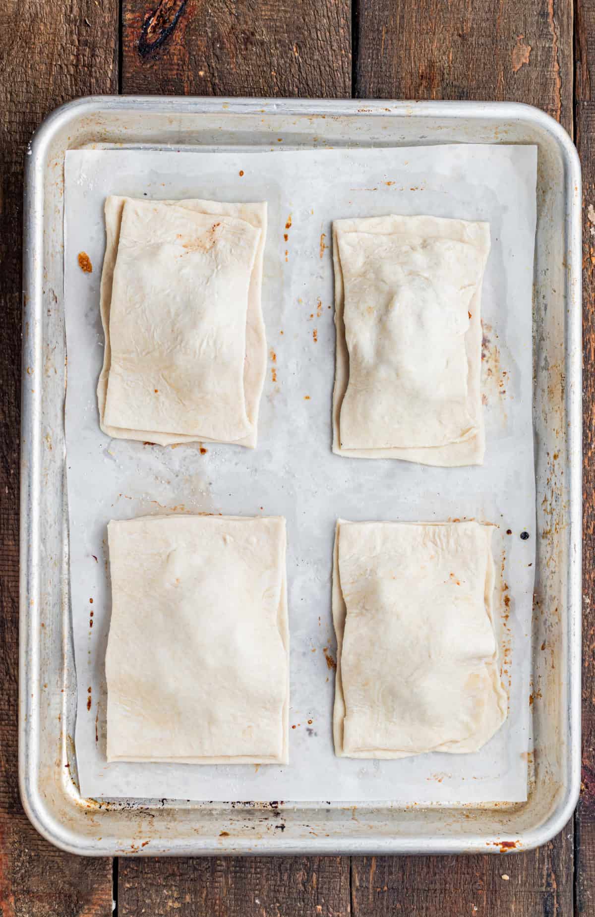 These Apple Hand Pies are filled with gooey apple pie filling wrapped in flaky puff pastry and baked until deeply golden and crisp. adding the top layer of puff pastry sheet to the hand pies.