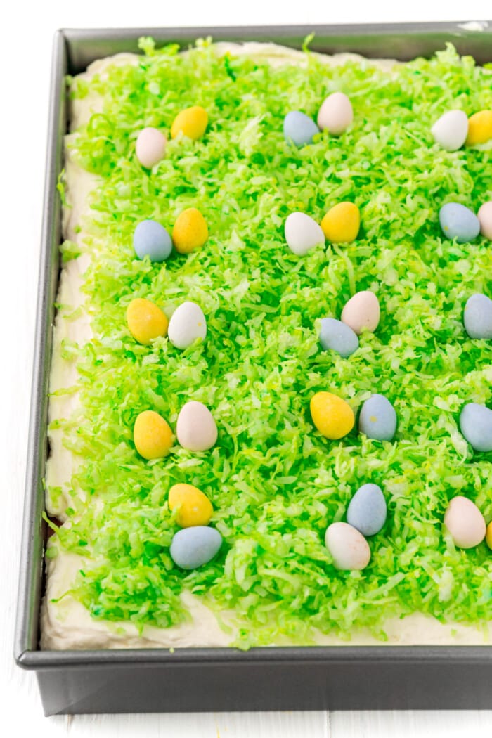 adding green coconut and candy eggs on top