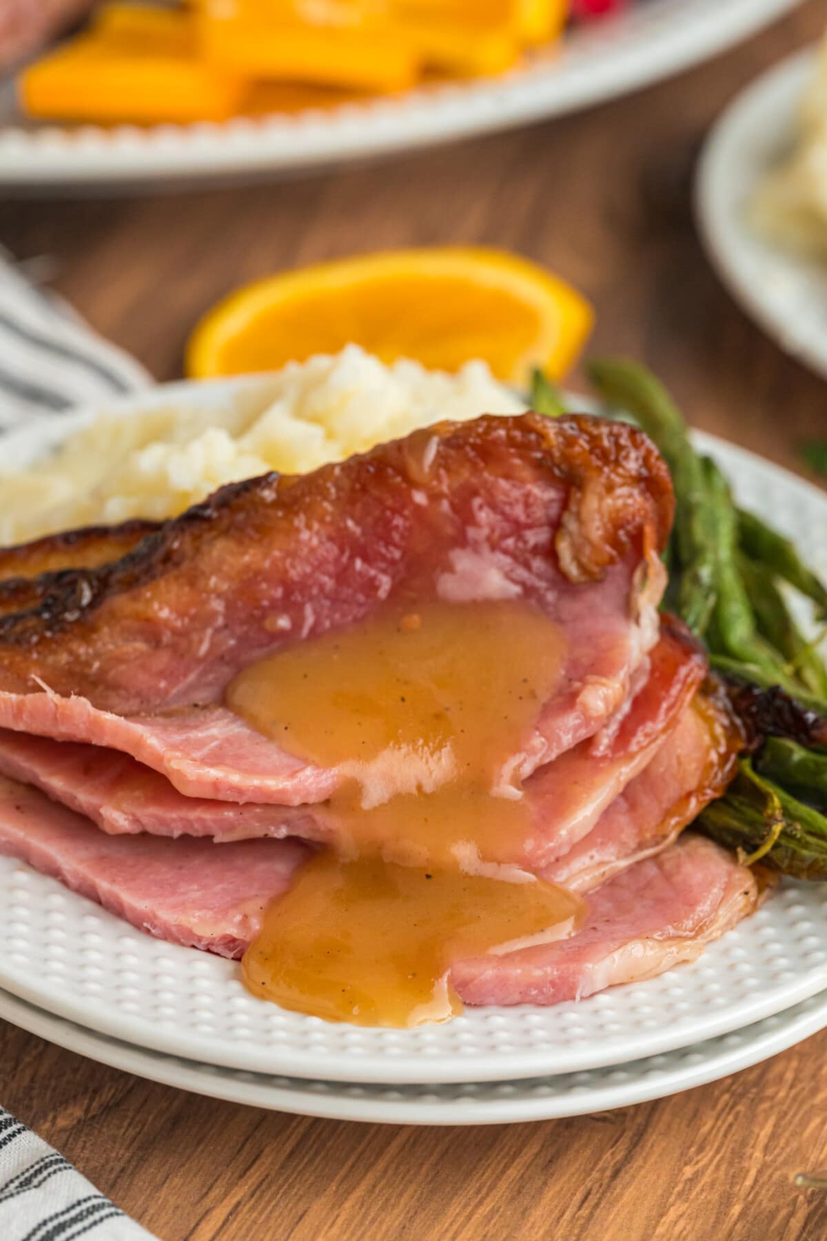 Orange Glazed Ham slices with gravy on a plate