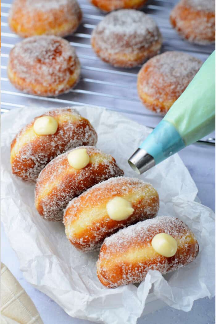 adding the vanilla filling to the donuts