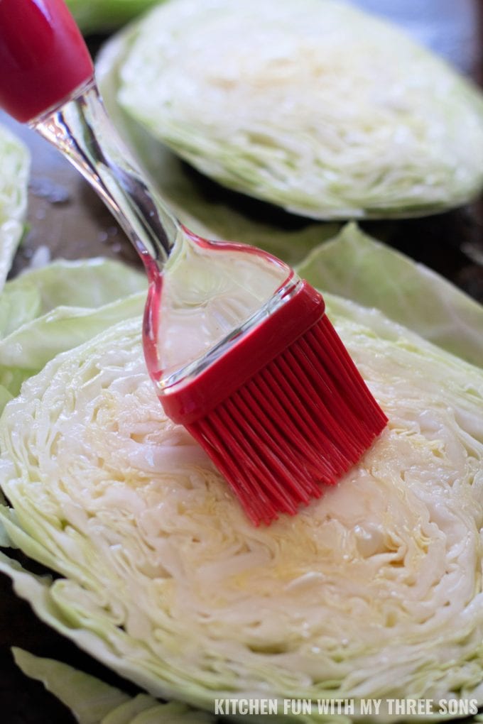 brushing oil onto slices of cabbage.