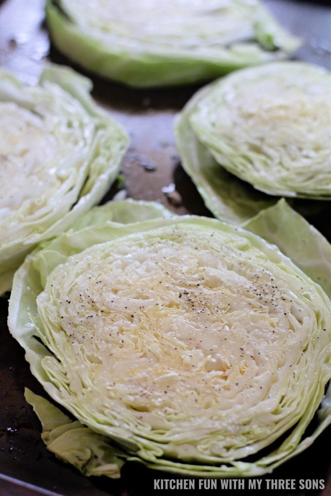 cabbage steaks ready to be baked on a baking sheet.