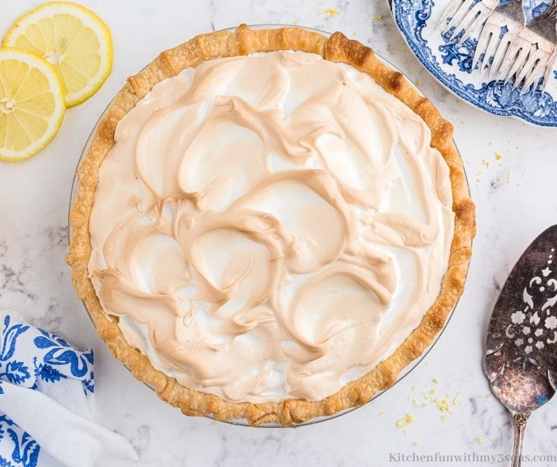 The whole lemon meringue pie with a large serving spoon beside it.