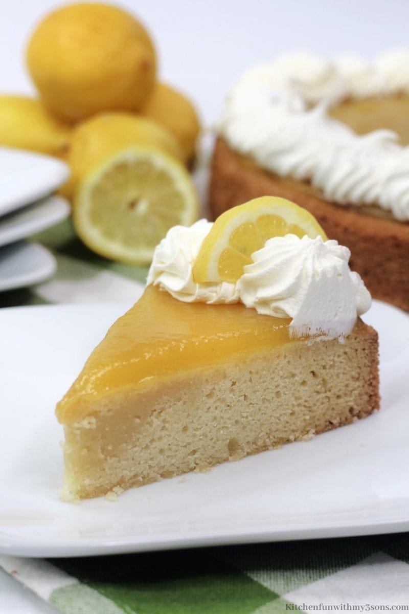 A piece of the lemon curd cake with a lemon wedge.