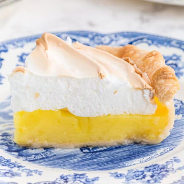 A slice of lemon meringue pie on a blue plate