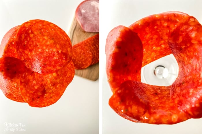 Slices of pepperoni over a wine glass