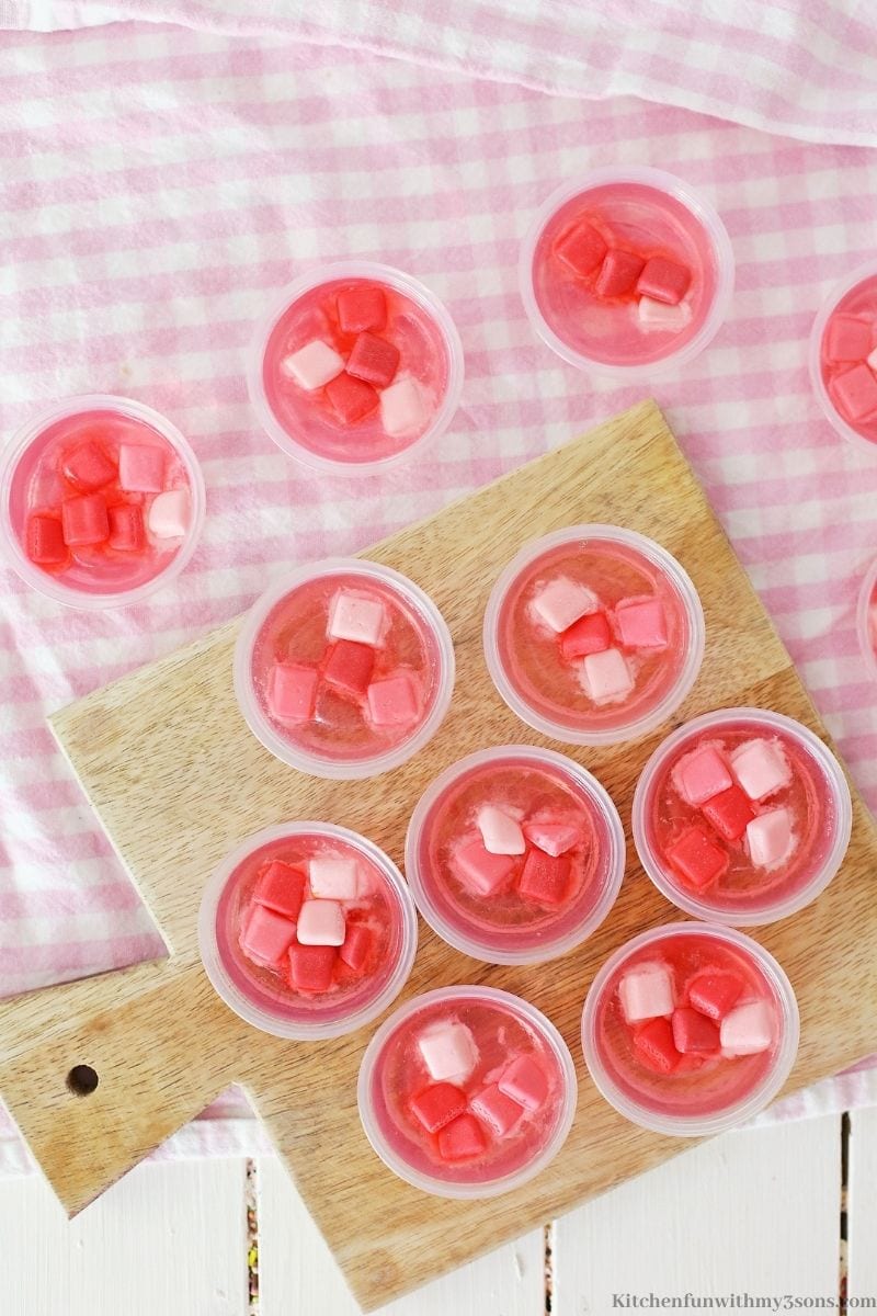 The jello shots on a pink cloth.