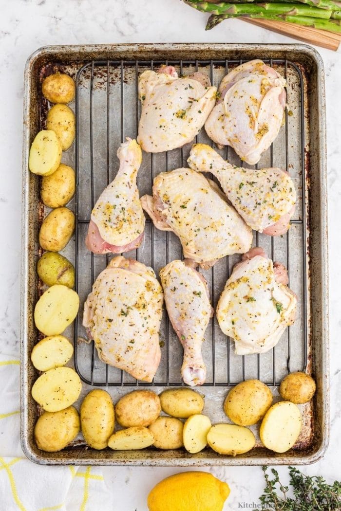 The chicken with the potatoes on a sheet pan.
